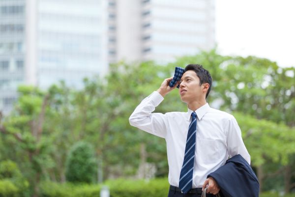 夏バテで体調不良を感じているビジネスマンの男性